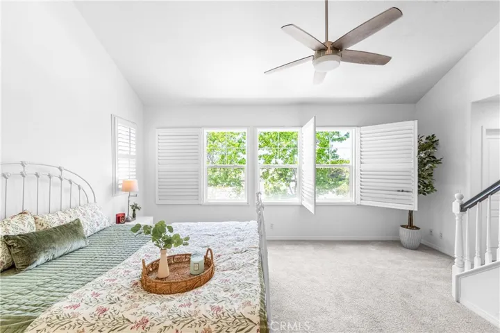 The expansive primary suite offers soaring ceilings, dramatic wall-to-wall windows, a unique upper loft retreat, spa-inspired bath with soaking tub, dual vanities, a linen closet, and a walk-in closet.