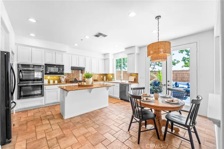 Designed for seamless everyday living and entertaining, the expansive great room flows effortlessly into the kitchen, dining, and breakfast areas with rich wood floors, recessed lighting, a cozy fireplace, and wall-to-wall windows.