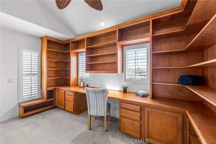 A stunning light -filled mezzanine retreat awaits at the top of t he stairs, featuring a wall-to-wall custom library office with wrap around built-ins, and an elevated loft space perfect for a studio, reading nook, gym or 5th bedroom.