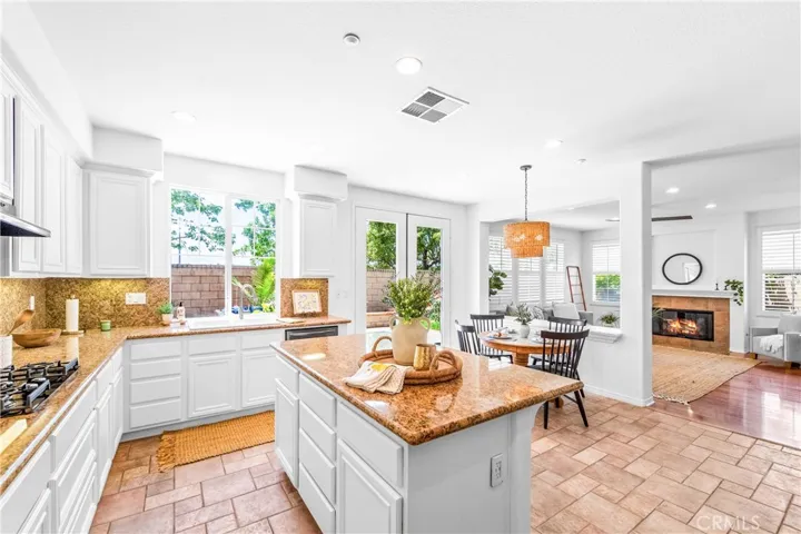 Spacious and beautifully connected to the living areas, the kitchen features a generous breakfast nook, center island with seating and storage, abundant cabinetry, walk -in pantry, and sunlit backyard views.