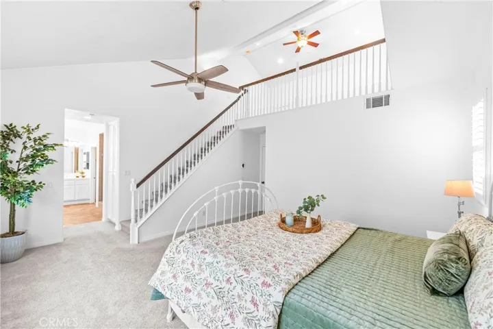 The expansive primary suite offers soaring ceilings, dramatic wall-to-wall windows, a unique upper loft retreat, spa-inspired bath with soaking tub, dual vanities, a linen closet, and a walk-in closet.