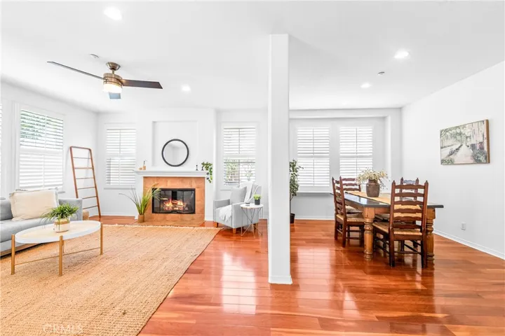 Designed for seamless everyday living and entertaining, the expansive great room flows effortlessly into the kitchen, dining, and breakfast areas with rich wood floors, recessed lighting, a cozy fireplace, and wall-to-wall windows.