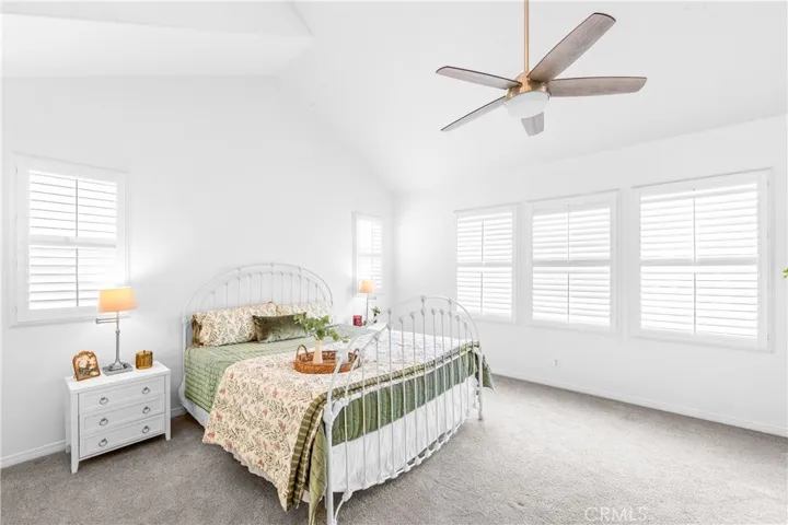 The expansive primary suite offers soaring ceilings, dramatic wall-to-wall windows, a unique upper loft retreat, spa-inspired bath with soaking tub, dual vanities, a linen closet, and a walk-in closet.