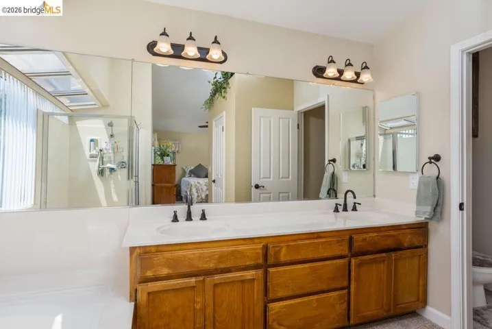 Dual vanity with wood-finish cabinetry and white countertops