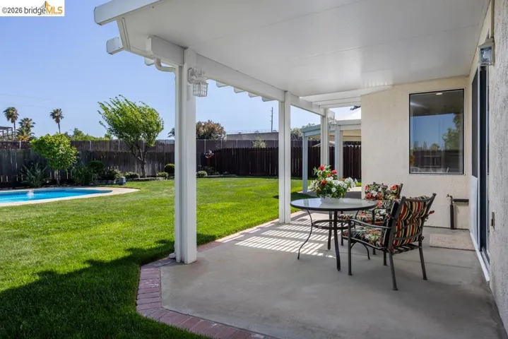 Covered patio featuring a concrete surface and white support columns