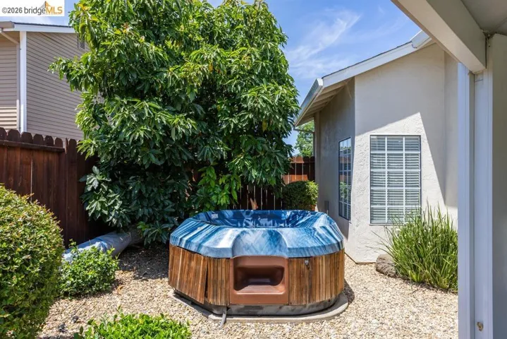 Private outdoor spa area featuring a wood-sided hot tub
