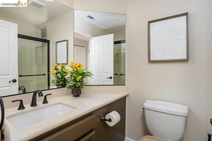 Bathroom vanity featuring a single undermount sink and matte black hardware