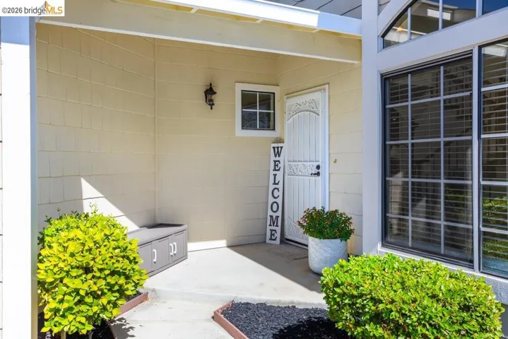Protected entry with decorative security screen door, vertical window, and exterior wall lantern