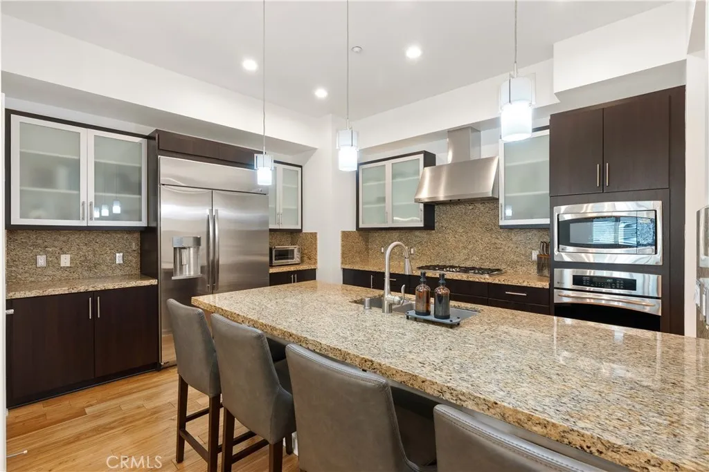 Beautifully updated kitchen with rich cabinetry, stone countertops, and generous prep space.