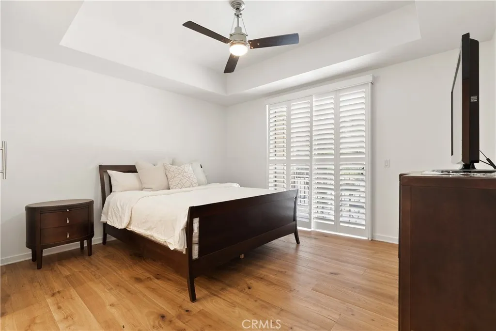 Spacious primary suite with large windows, balcony access, designer touches, and relaxing ambiance.
