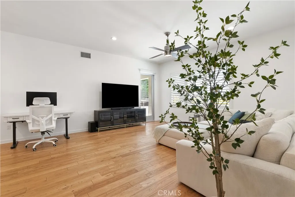 Bright and welcoming enterance with soaring ceilings, warm wood flooring, and abundant natural light.