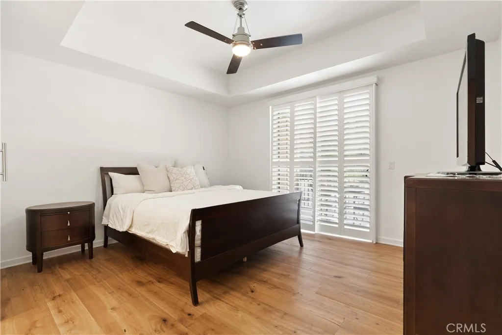 Spacious primary suite with large windows, balcony access, designer touches, and relaxing ambiance.