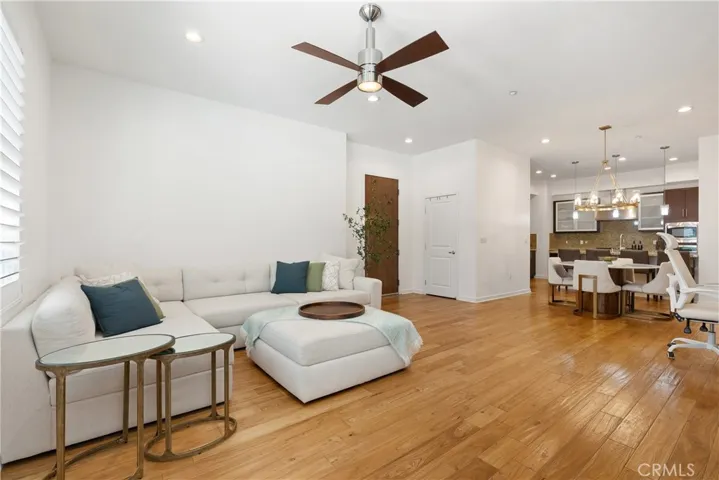 Modern living room featuring contemporary finishes, sleek ceiling fan, and an airy open layout.