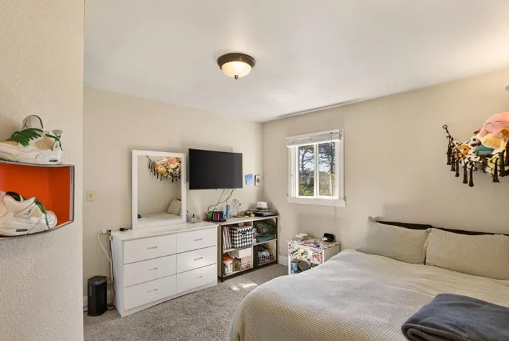 Hall bedroom with dual pane window and horizontal blinds