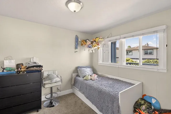 Hall bedroom with dual pane windows and vertical blinds