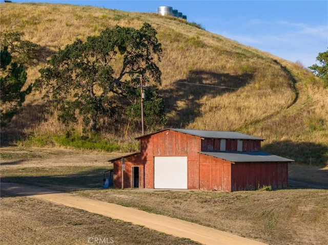 Spacious barn next to the main house, small road leading up to the water tanks and another plateau