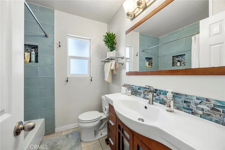 Full bathroom, upgraded with teal accents.