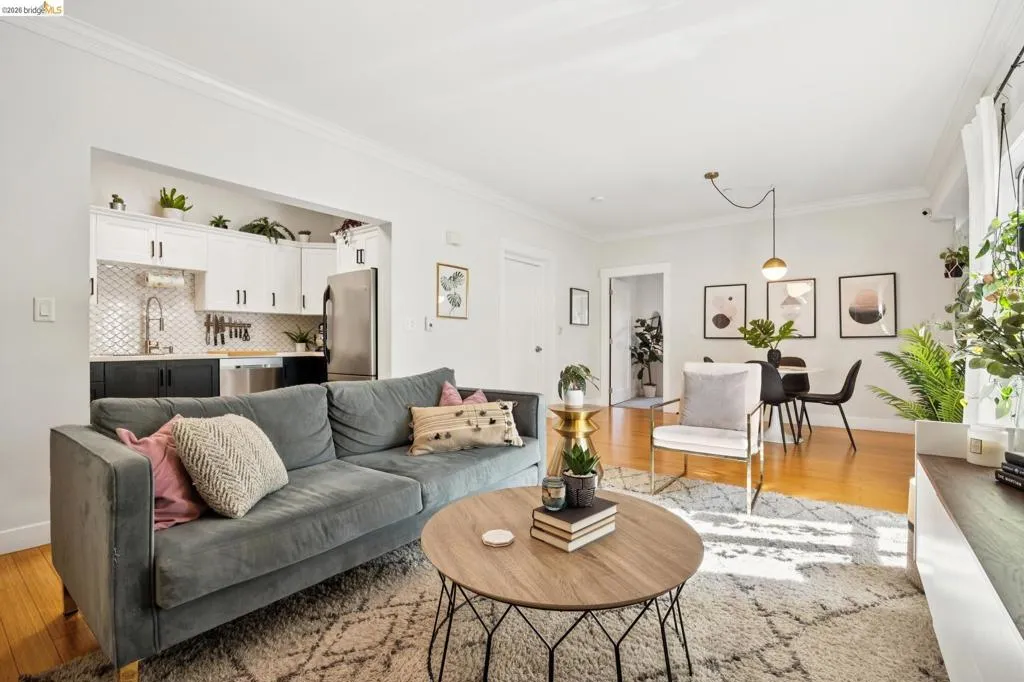 Open-concept living space featuring wood-finish flooring, crown molding, and recessed lighting
