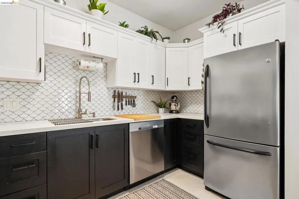 Contemporary kitchen featuring two-tone cabinetry with white upper and dark lower units