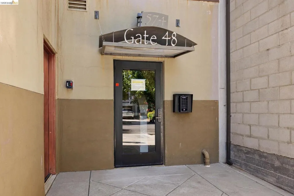 Entryway featuring a glass-paneled door, metal awning, and wall-mounted intercom system