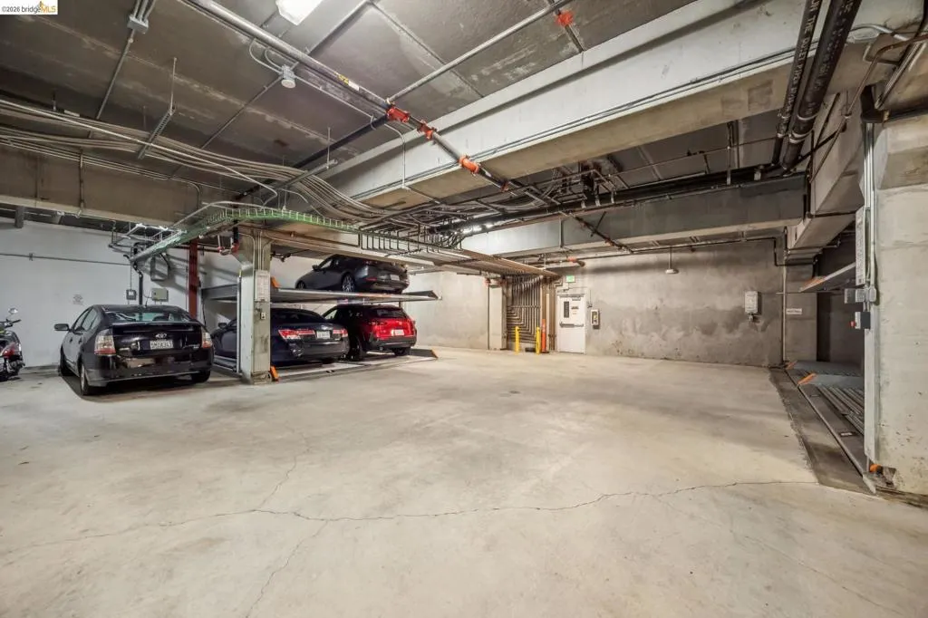 Dedicated parking garage featuring concrete flooring and exposed overhead utilities