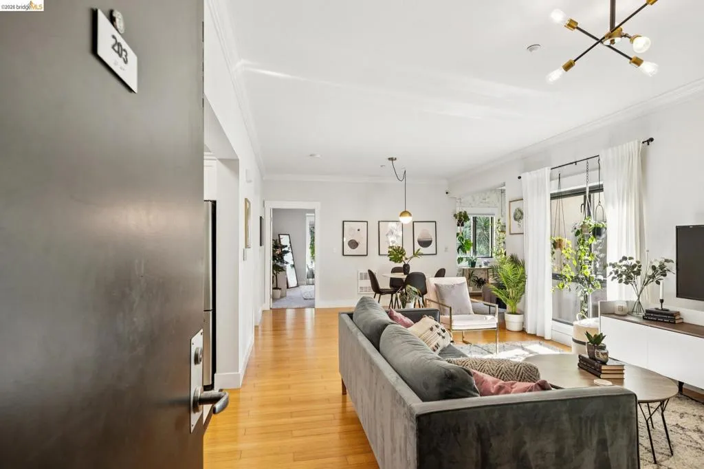 Open-concept living area featuring wood-finish flooring, crown molding, and recessed lighting