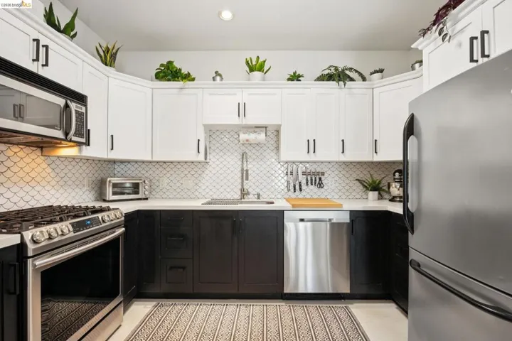 Modern kitchen featuring two-tone cabinetry with white upper and dark lower units