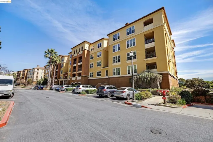 Multi-story residential building featuring a stucco exterior with decorative accents