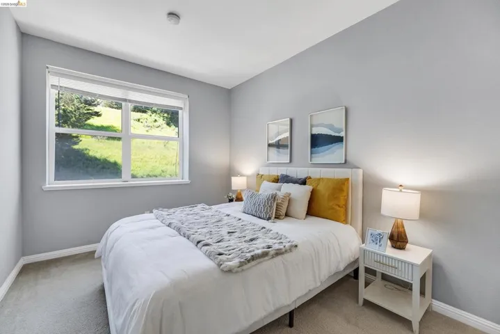 Room featuring a large window, soft gray wall paint, and light-toned carpeting