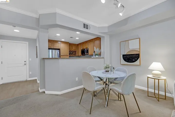 Open-concept dining area with recessed lighting, carpet flooring, and crown molding