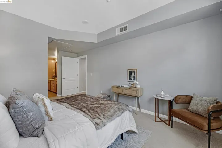 Carpeted bedroom featuring light gray walls, a tray ceiling, and a recessed ceiling light