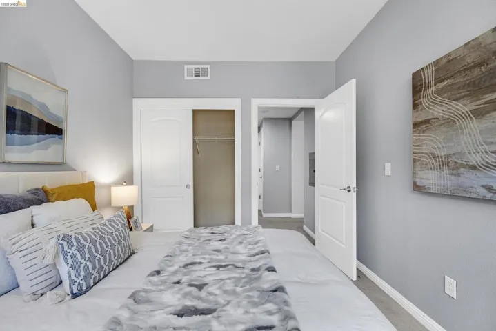 Carpeted bedroom featuring light gray walls, a built-in closet with sliding doors, and a white paneled interior door