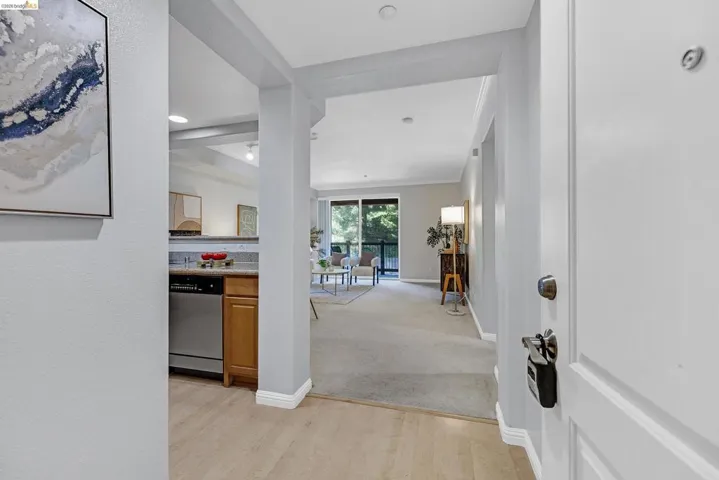 Entryway with wood-finish flooring opening to a living area with a balcony