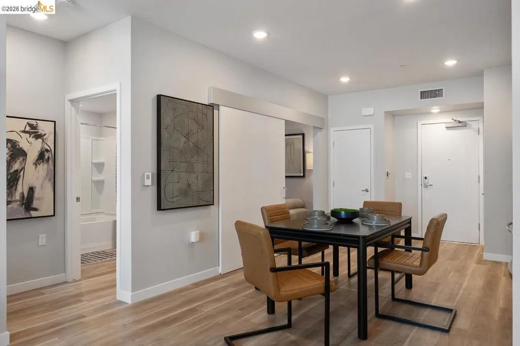 Dining room with light wood finished floors and recessed lighting