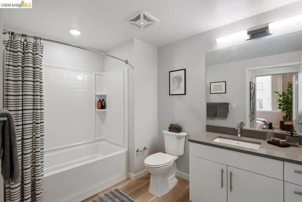 Full bathroom featuring shower / tub combo, light wood-style flooring, and vanity