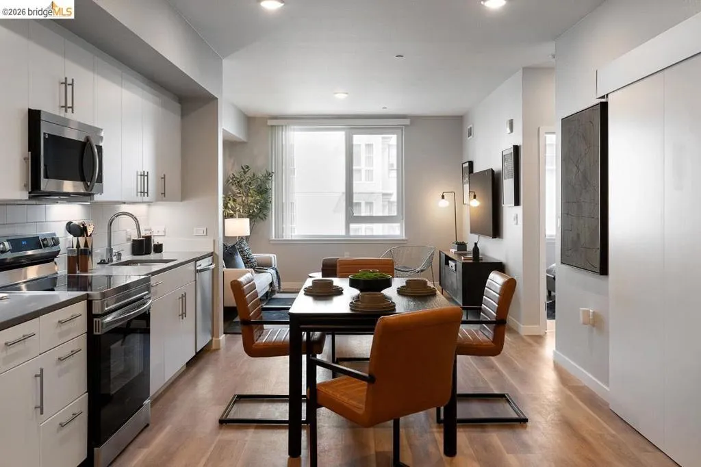 Kitchen with appliances with stainless steel finishes, light wood-style floors, recessed lighting, backsplash, and dark countertops
