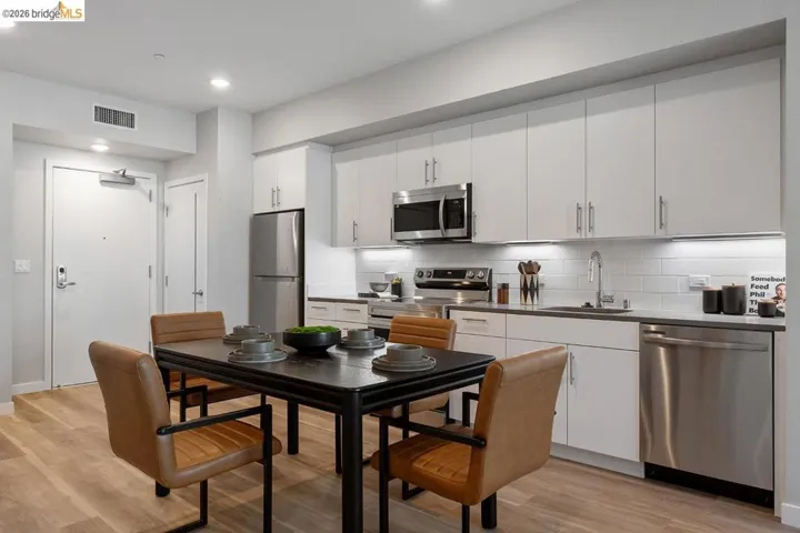 Kitchen with appliances with stainless steel finishes, white cabinetry, backsplash, light wood-style flooring, and recessed lighting