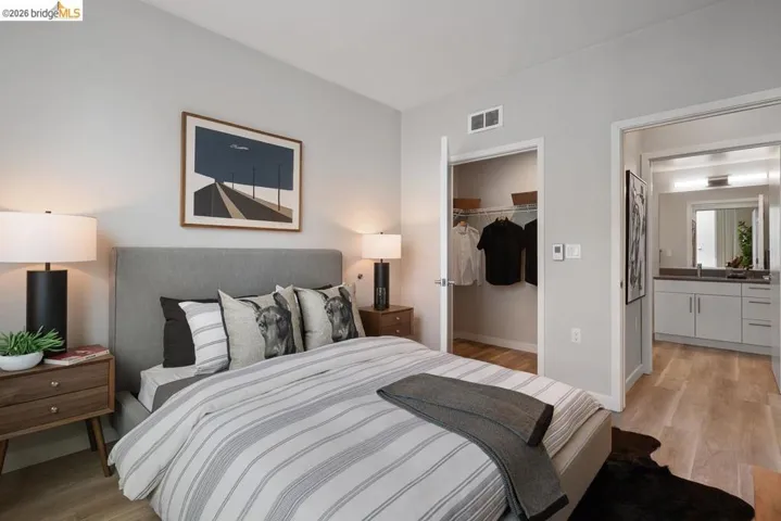 Bedroom with light wood-type flooring and a spacious closet
