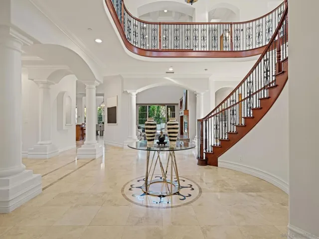 Gorgeous stair case is a signature of the entry. Formal dining room just off the entrance has its own courtyard entrance