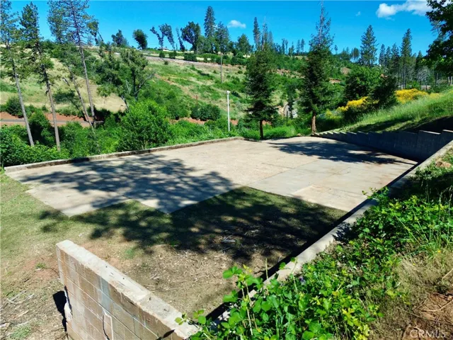 Existing concrete pad and retaining wall from prior homesite, previously improved with an approximately 3,016 sq ft residence.