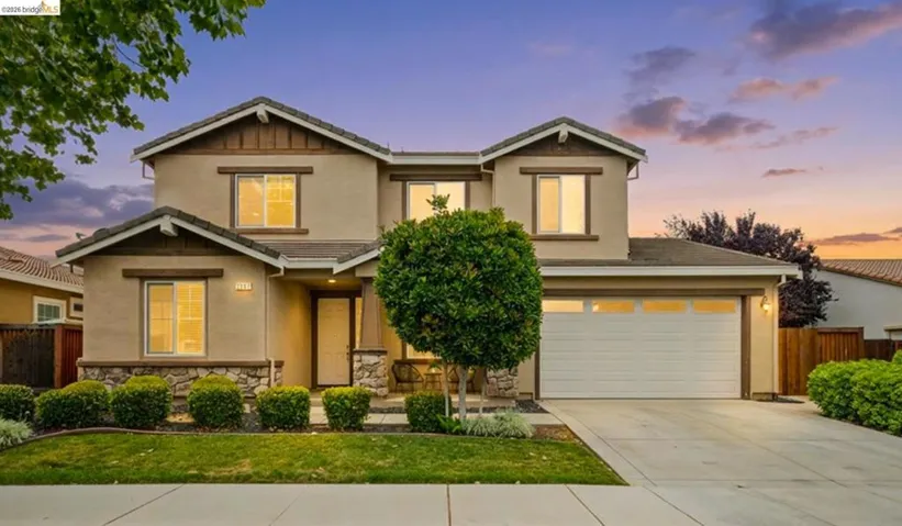 Two-story residence featuring a stucco exterior with stone accents and a prominent two-car​​‌​​​​‌​​‌‌​​‌​​​‌‌​​​‌​​‌‌​​‌‌​​‌‌​​​​ garage
