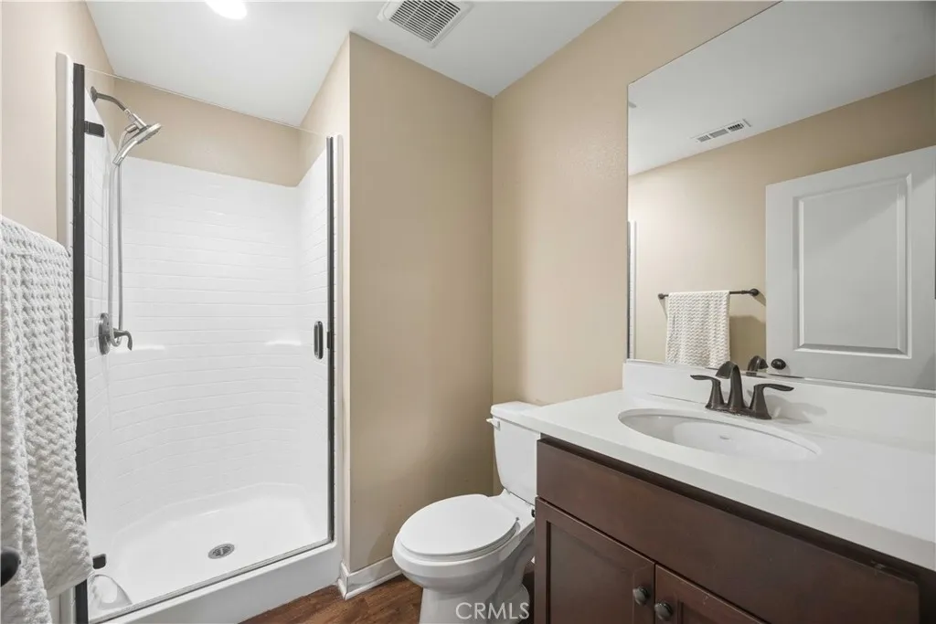 Ground-floor full bath featuring walk-in shower with glass enclosure and dark tone fixtures