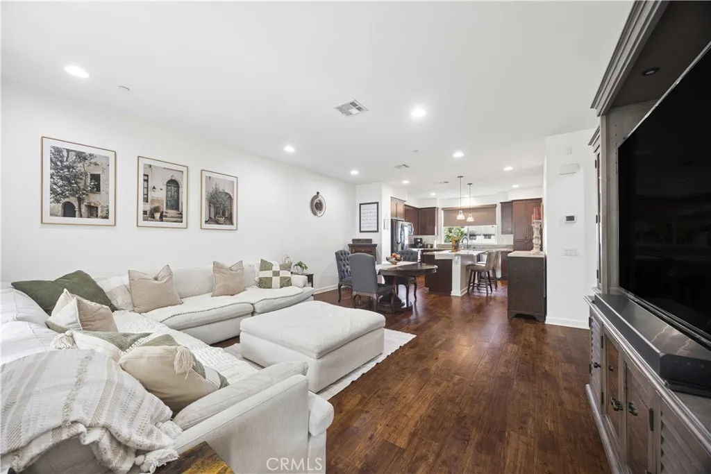 Second-level great room featuring expansive open-concept layout, wood laminate floors and a stunning view straight through to the gourmet kitchen