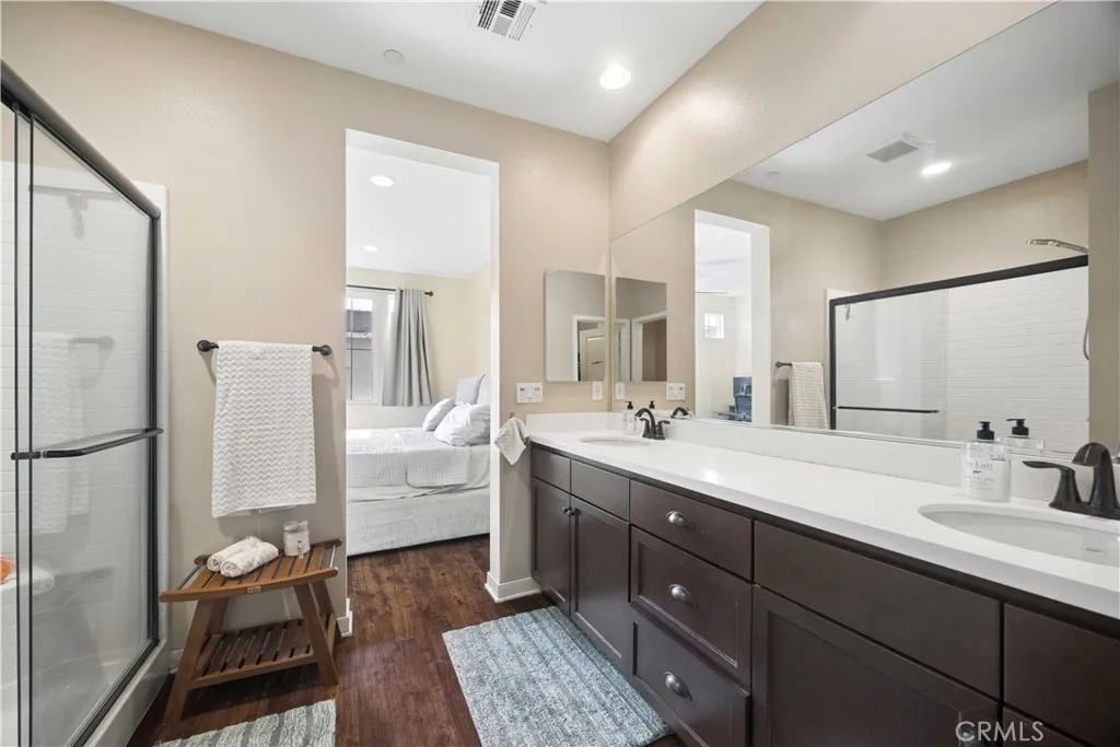 Primary bathroom features include dual sinks with ample counter and cabinet space, spacious walk-in closet, enclosed walk-in shower and a water closet.