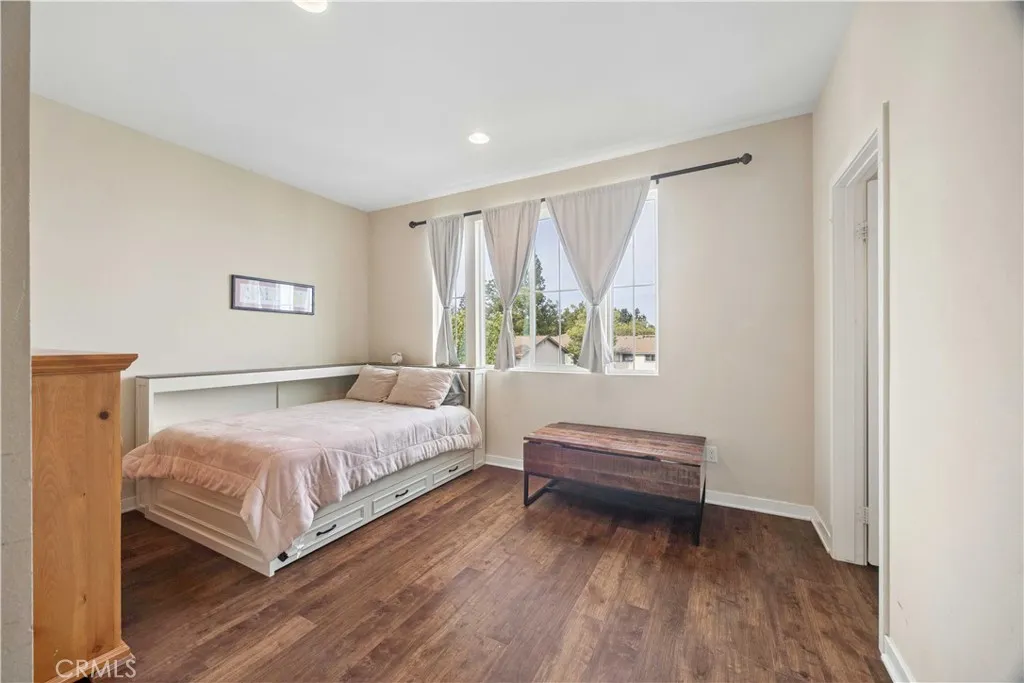 Bright third-level secondary bedroom with hardwood floors, natural light, and en-suite bath.