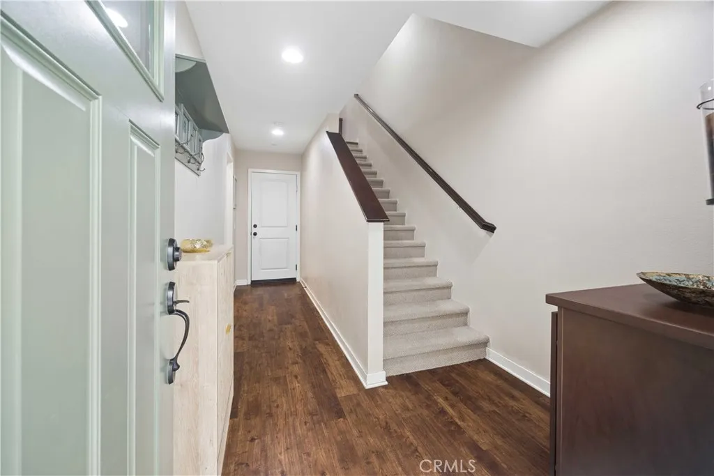 Welcoming entry foyer with rich wood laminate floors, recessed lighting & direct staircase access to main living level