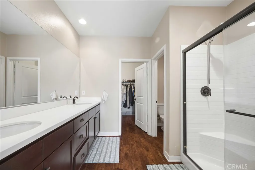 Primary bathroom features include dual sinks with ample counter space, spacious walk-in closet, enclosed walk-in shower and a water closet.