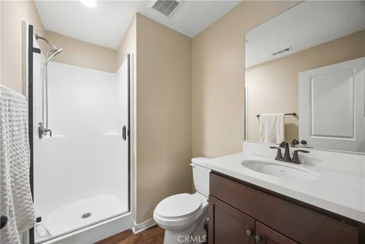 Ground-floor full bath featuring walk-in shower with glass enclosure and dark tone fixtures