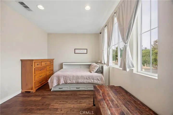 Bright and spacious third-level secondary bedroom with hardwood floors, natural light, and en-suite bath