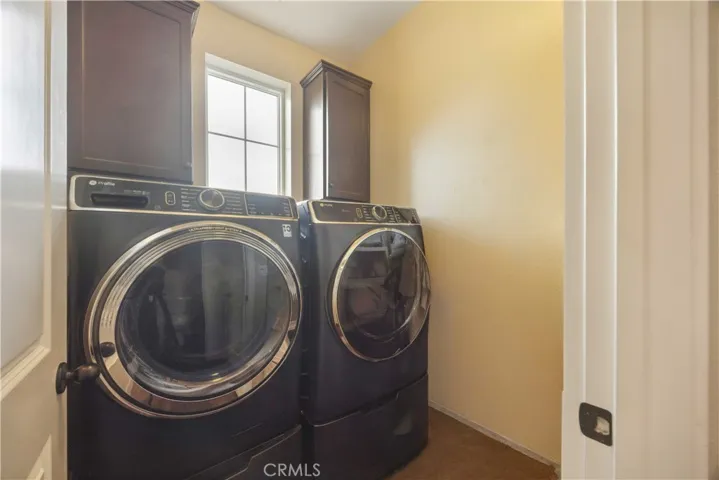 Full size dedicated laundry room located on main level complete with upper cabinetry storage.